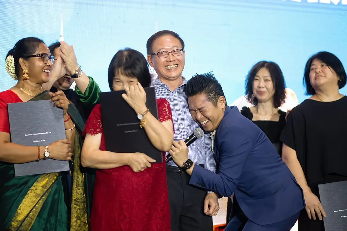 James Yang laughing with award recipients on stage